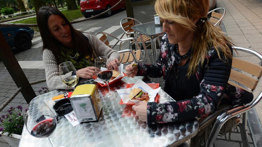 Dos mujeres degustando uno de los pinchos de un local asociado a Hostelería de Sama.