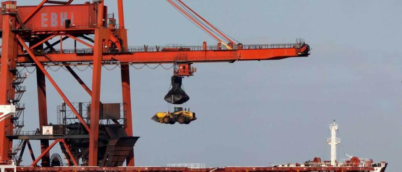 Una grúa pórtico de EBHISA introduce maquinaria en la bodega de un barco granelero.