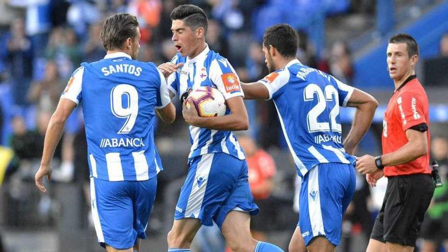 Carlos Fernández celebra un gol en Riazor con Christian Santos y Pablo Marí.