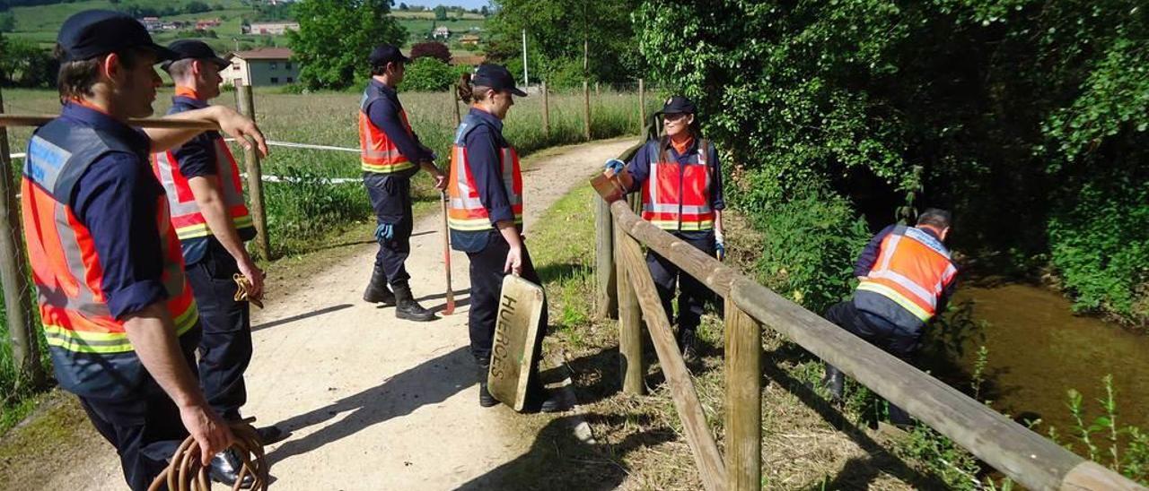 Voluntarios de Protección Civil de Gijón, limpiando el arroyo de Llantones en un Día del Medio Ambiente.