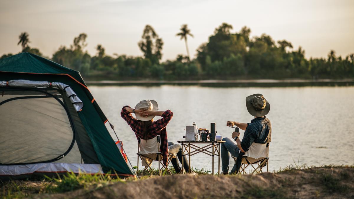 Cheerful Young Couples camping with morning coffee.