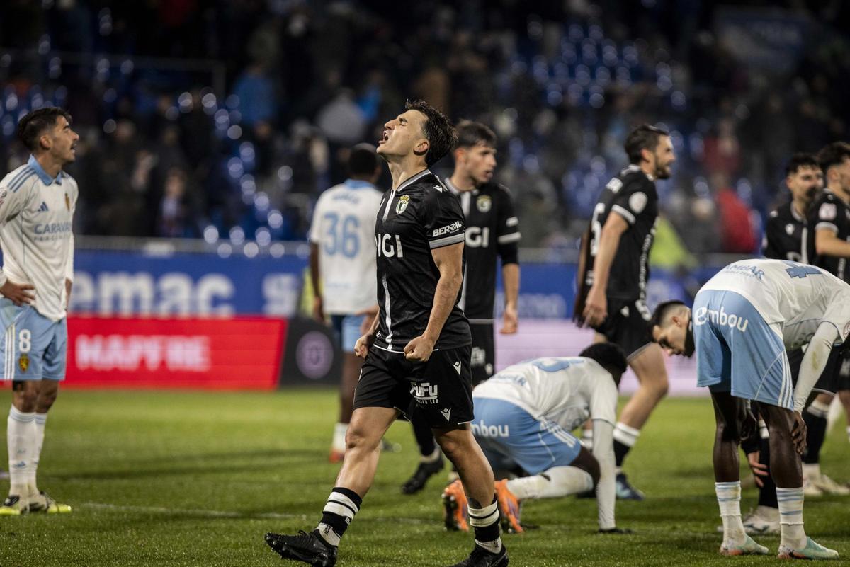 Los jugadores del Burgos celebran su clasificación en Copa ante la desolación de los zaragocistas en el último enfrentamiento entre ambos.