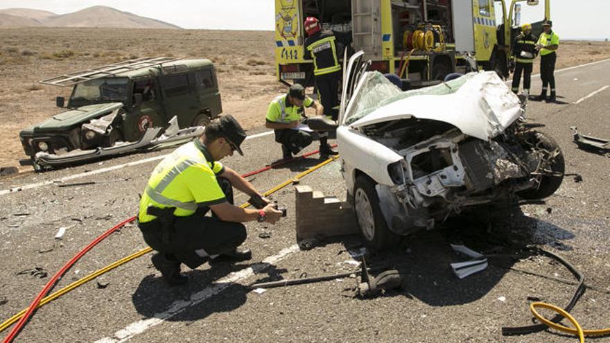 Agentes de la Guardia Civil y los bomberos, junto a los dos vehículos implicados en el choque mortal, ayer, en Fuerteventura.