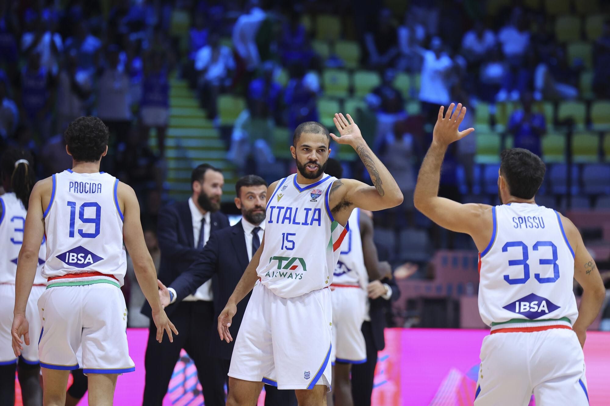 Italy's Darius Thompson, center, high five with his teammate Marco Spissu during the Eurobasket, European Basketball Championship Group C match between Spain and Italy at Spyros Kyprianou Arena, in Limassol, Cyprus, Tuesday, Sept. 2, 2025. (AP Photo/Chara Savvidou)