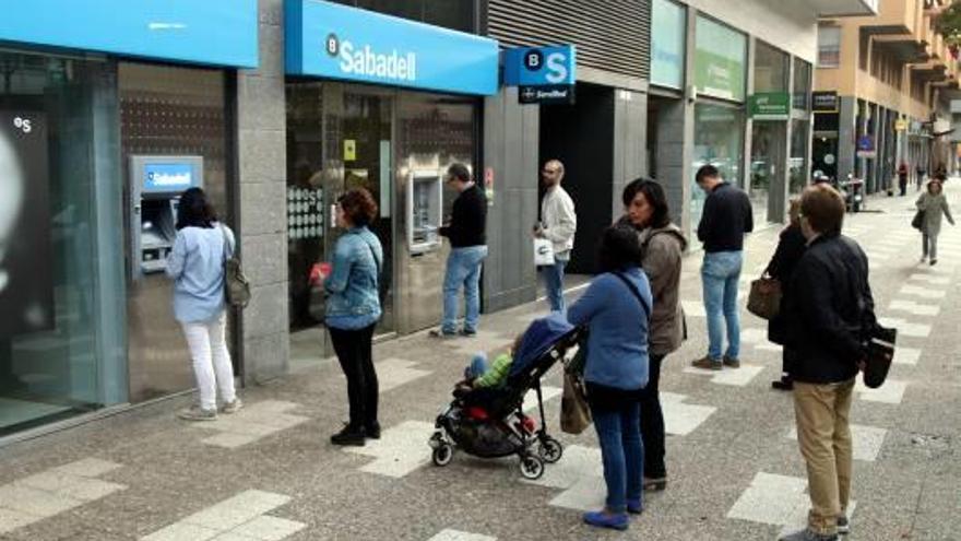 Gironins fent cua per treure diners del Banc Sabadell el 20 d&#039;octubre passat.