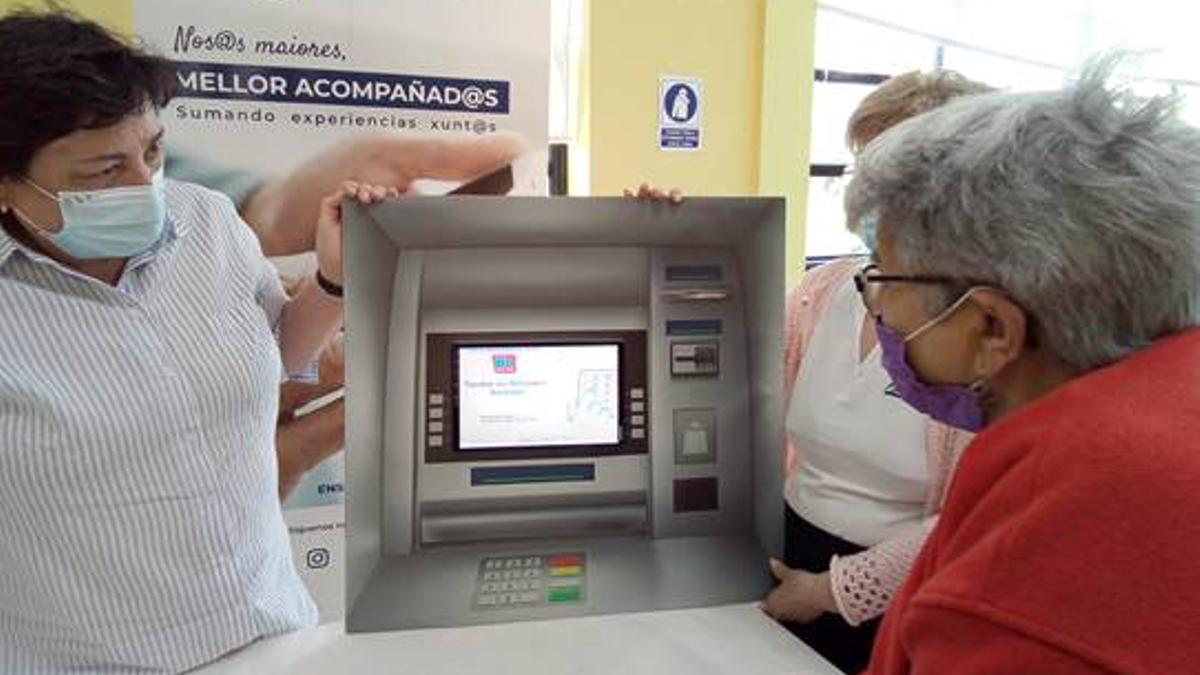 Una alumna con el simulador de cajero automático en el programa “Mellor acompañados”