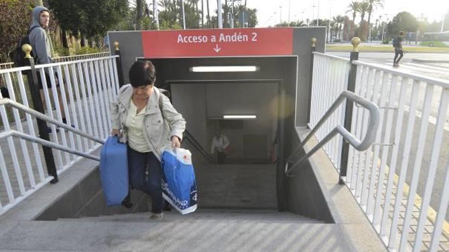 Una usuaria, cargada con maleta y bolsas, saliendo del andén dos por la salida de emergencia, tras cerrarse el acceso.