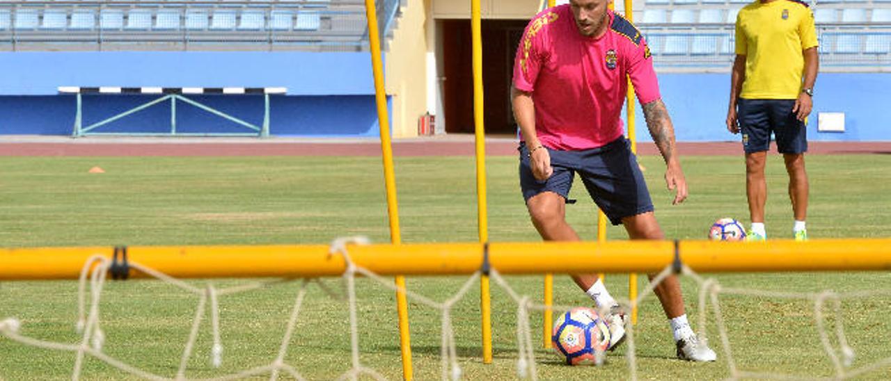 El mediocentro Javi Castellano esquiva varias picas con el balón en el Municipal de Maspalomas, la semana pasada, con Rafa Cristóbal de fondo.