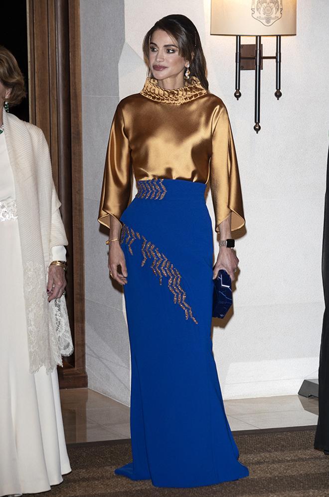 Rania de Jordania con falda azul klein y blusa dorada