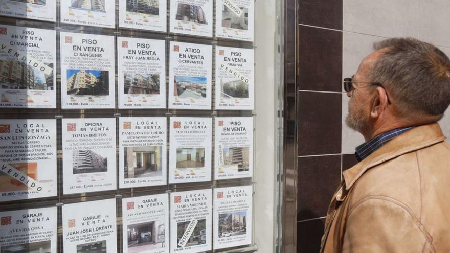 Un hombre consulta los anuncios de una agencia inmobiliaria de Zaragoza. | ÁNGEL DE CASTRO