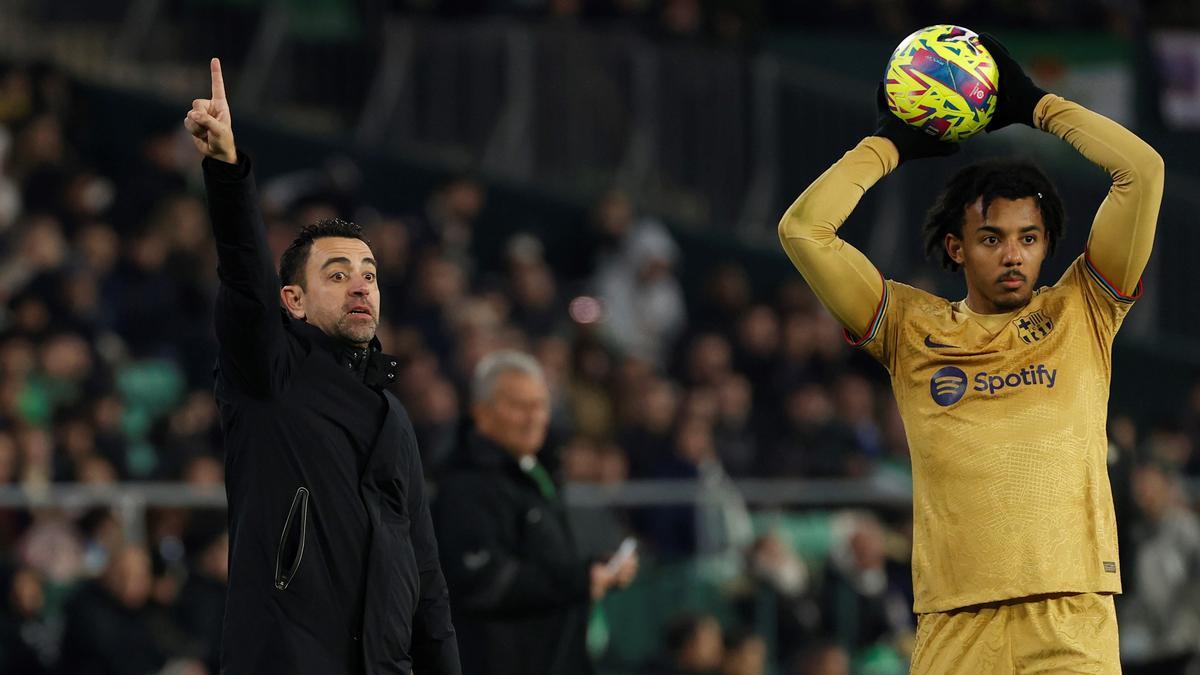 Xavi da órdenes mientras Koundé se dispone a lanzar un saque de banda en el Betis-Barça del Villamarín.