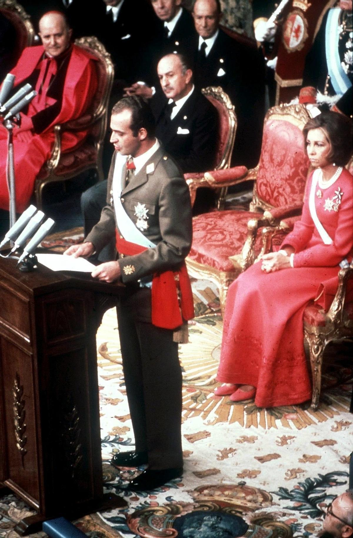 Der damalige neue spanische König Juan Carlos (M) während seiner Thronrede nach seiner Vereidigung im Ständeparlament in Madrid. Hinter ihm sitzend die damalige Königin Sofia.