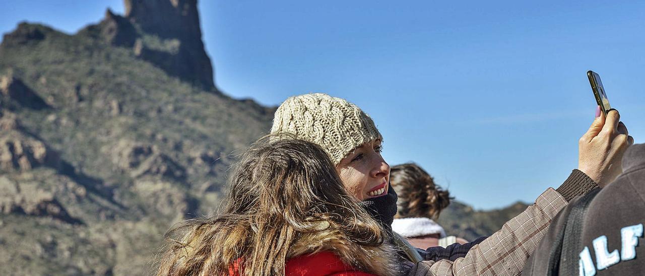 Dos mujeres se sacan una foto con un teléfono móvil en Tejeda, con el Roque Bentayga de fondo. | | LP/DLP