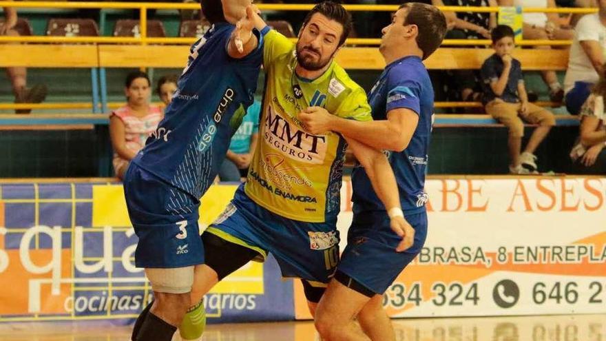 Dos jugadores del Teucro obstaculizan a Jortos que trata de lanzar a puerta, en el partido de ida.