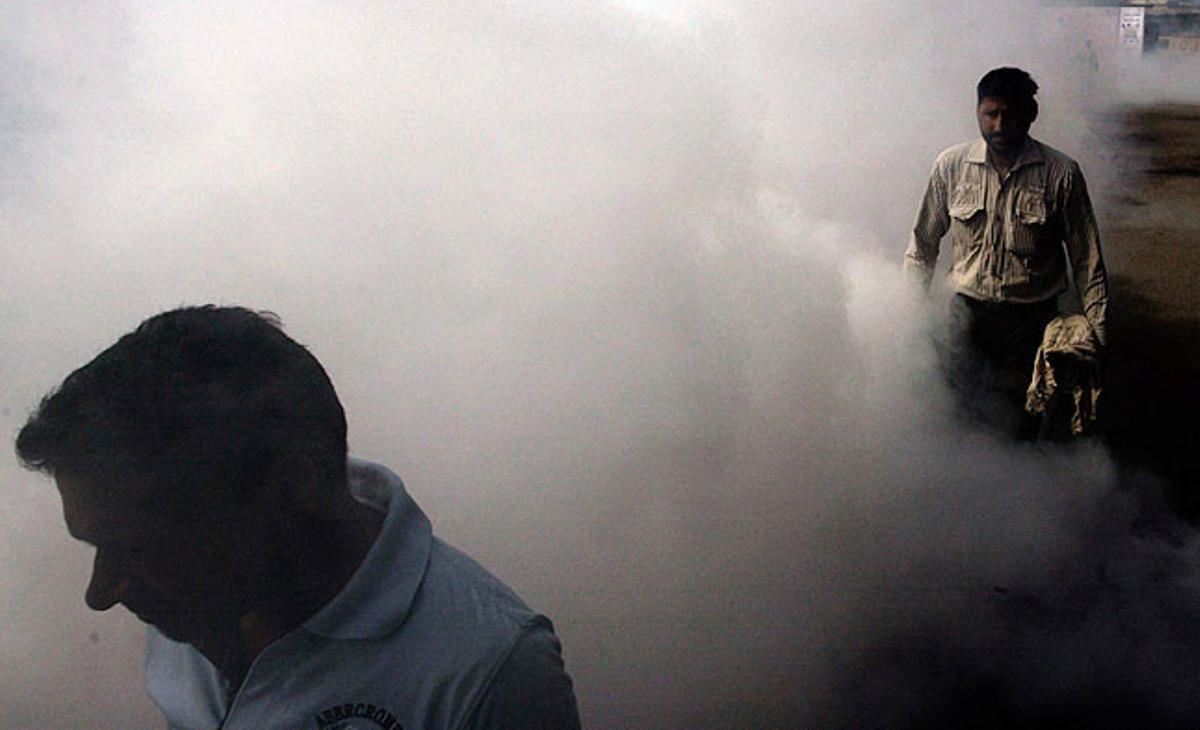 Diverses persones caminen per una àrea acabada de fumigar durant la neteja dels carrers com a part del programa ’Fem que Amrítsar brilli’, una iniciativa de l’alcalde de la ciutat d’Amrítsar (nord de l’Índia). L’objectiu d’aquesta campanya és aconseguir una neteja ecològica de la ’ciutat sagrada’.