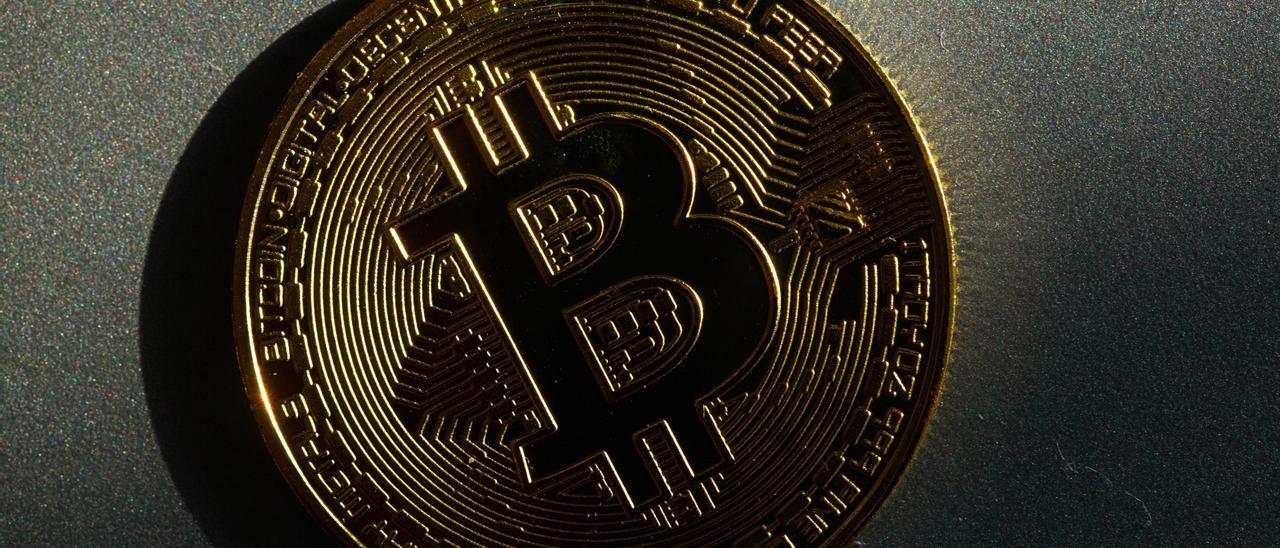 Una moneda con el logo del bitcoin, la criptodivisa más famosa, impreso.