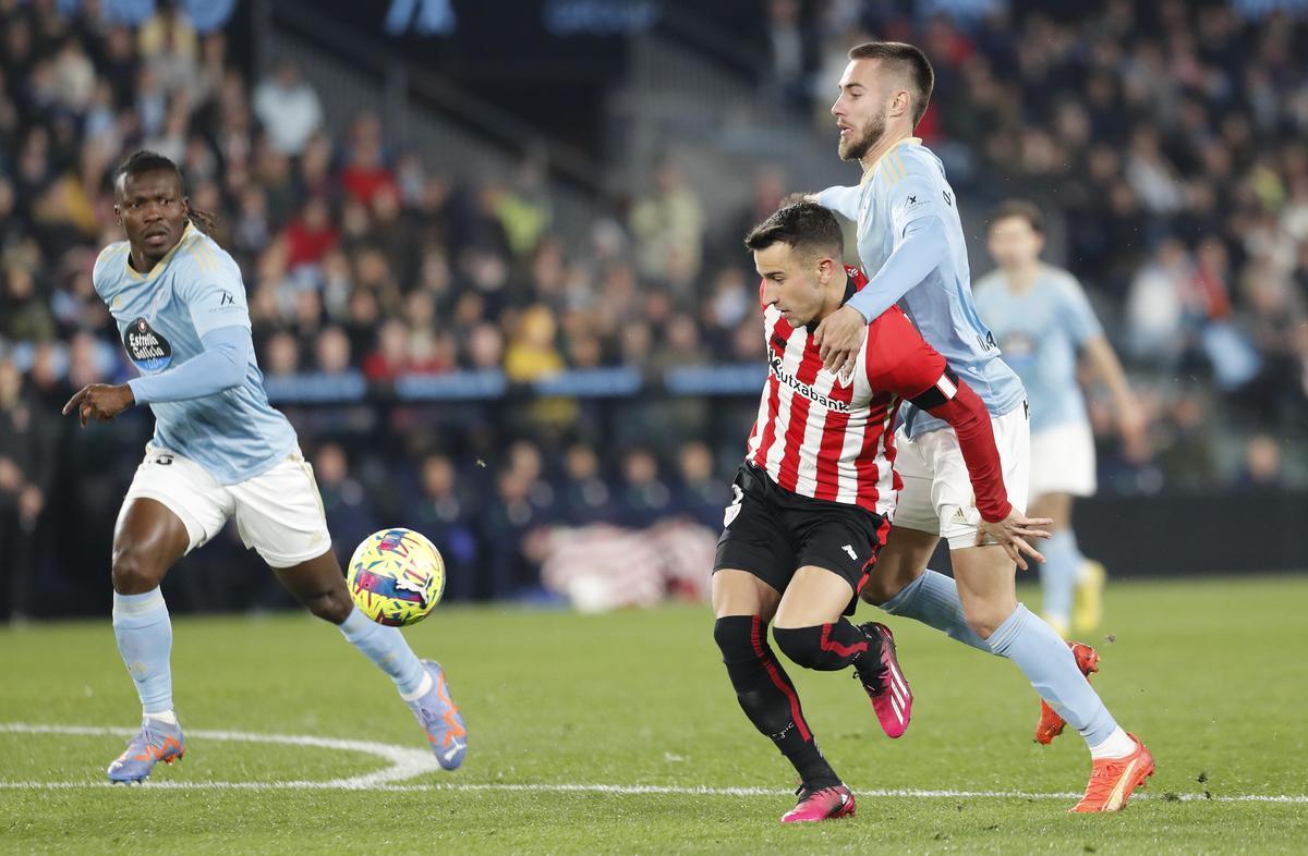 El delantero del Athletic Club, Álex Belenguer (2d), intenta llevarse el balón ante el defensa del Celta, Óscar Mingueza, durante el encuentro correspondiente a la jornada 19 de primera división Domingo en el estadio de Balaidos, en Vigo. EFE / Salvador Sas.