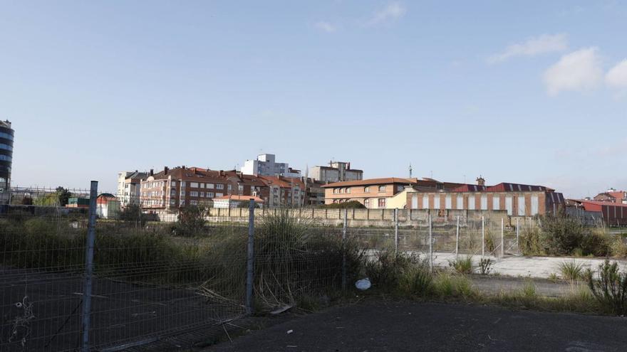 Parte de los terrenos del antiguo astillero Naval Gijón, con la valla que separa la parcela municipal de la de Pymar. | ÁNGEL GONZÁLEZ