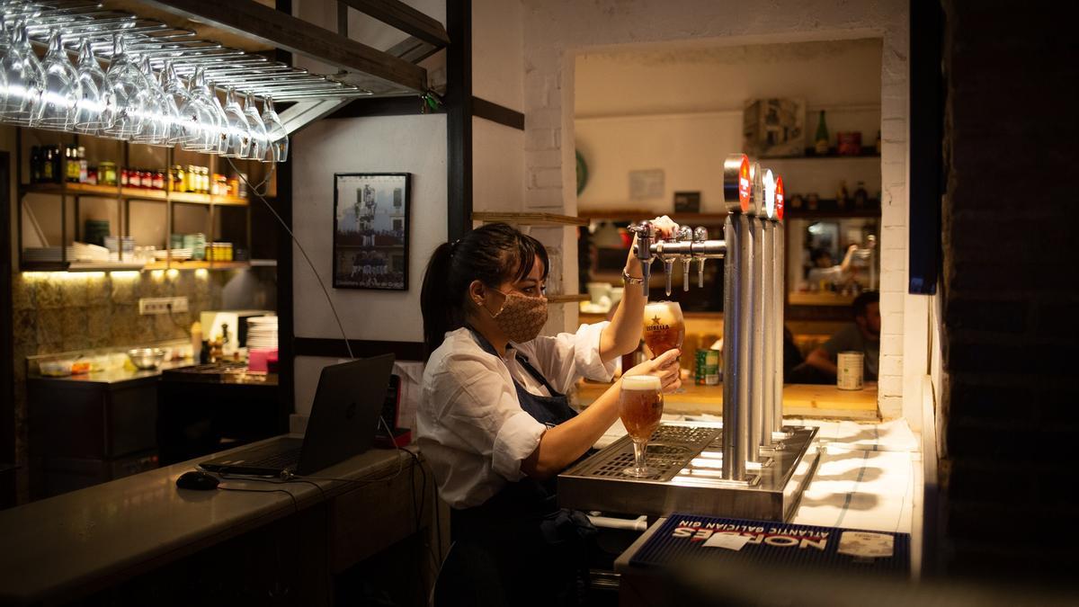 Una camarera trabaja en un bar.