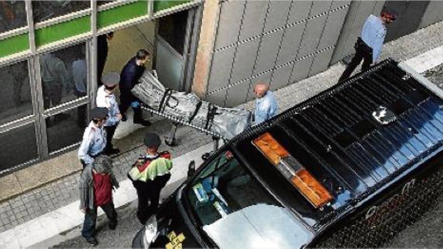 Membres dels serveis funeraris de Barcelona i del jutjat de guàrdia retirant el cadàver, ahir al matí