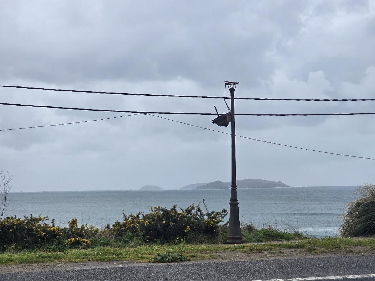 Una de las farolas deterioradas. Al fondo, la isla de Ons.