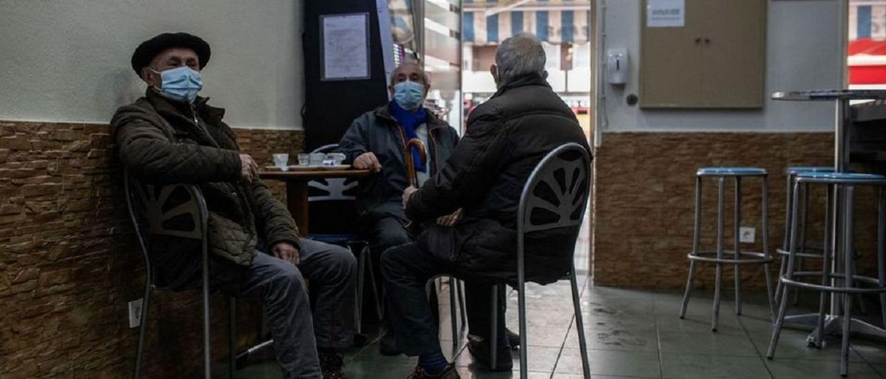 Tres personas con la mascarilla puesta en el interior de un bar de Zamora.