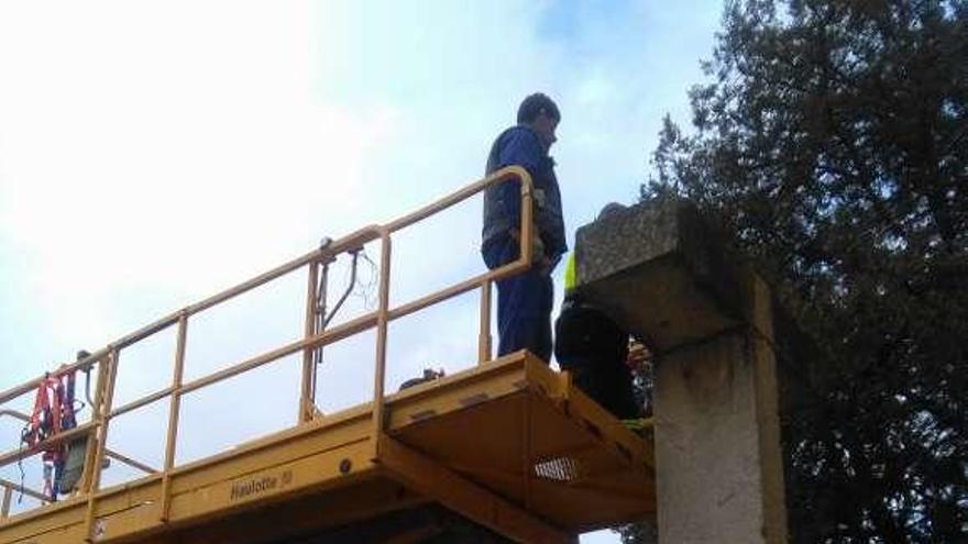 Operarios municipales retiran el monumento franquista.