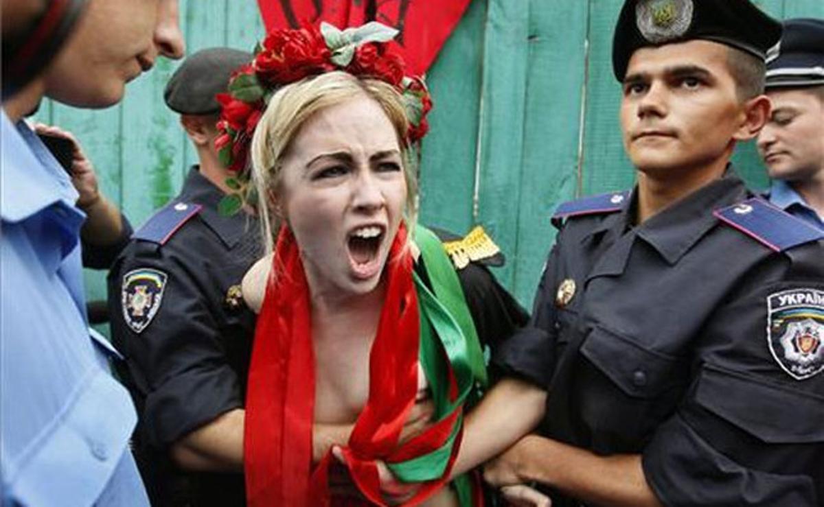 Efectius de la policia ucraïnesa detenen una militant del moviment feminista FEMEN durant una protesta en ’top less’ davant el Parlament de Kíev, Ucraïna.