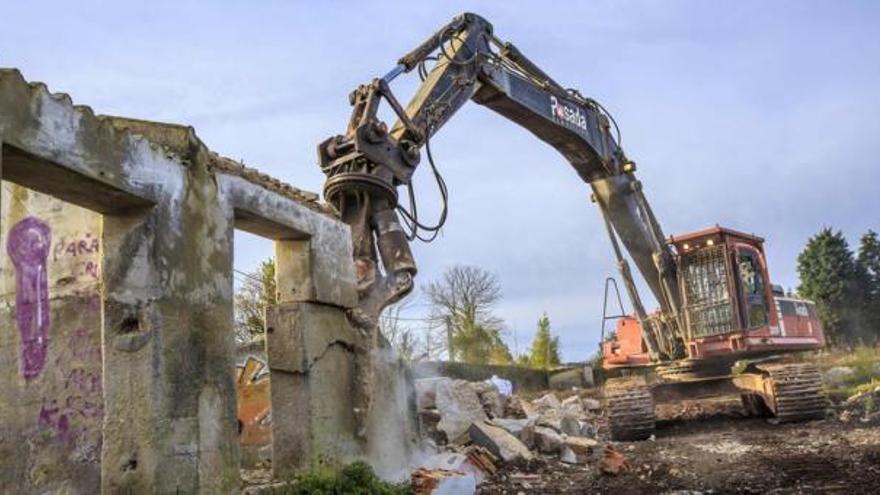 Una máquina trabaja en la demolición de uno de los edificios que quedaban en pie en la zona de la Pecuaria. | posada