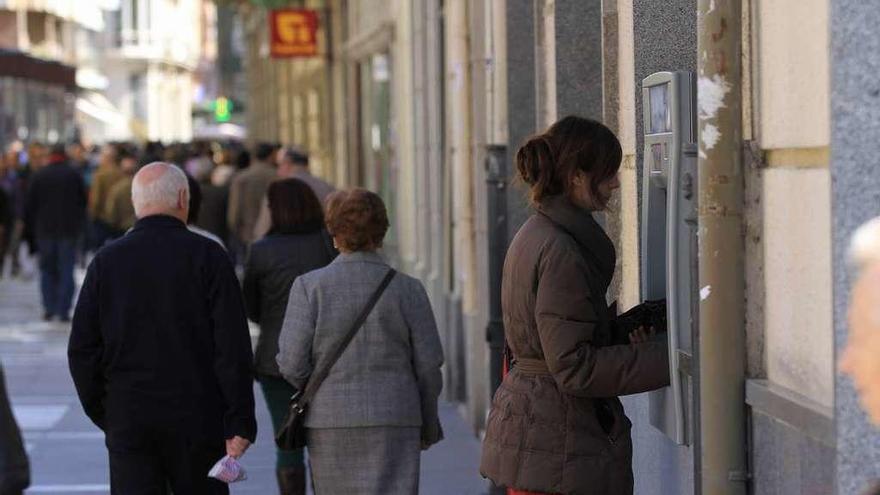 Una mujer saca dinero de un cajero automático.