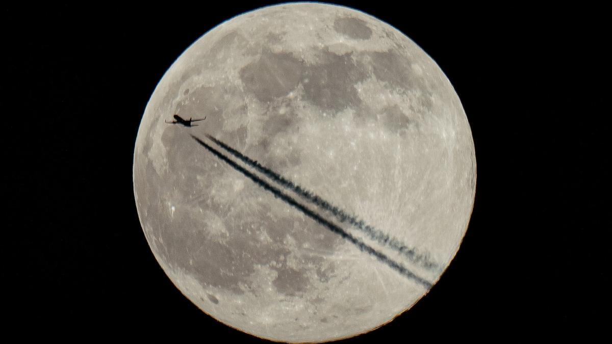 Un avión surca el cielo del Reino Unido en la primera luna llena de 2022, el 18 de enero pasado.