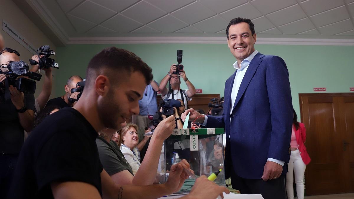 El presidente de la Junta y candidato del PP a la reelección, Juanma Moreno, deposita la papeleta con su voto en su colegio electoral.