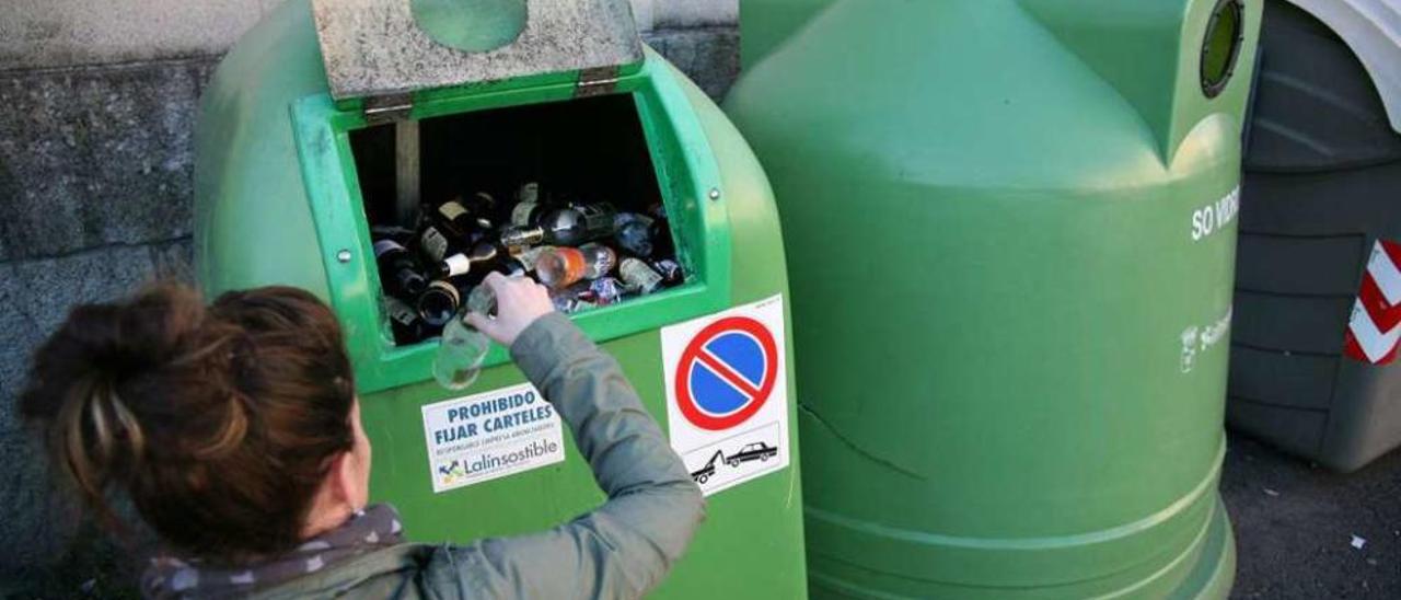 Una vecina de Lalín recicla un envase de vidrio en un contenedor. // Bernabé/Luismy