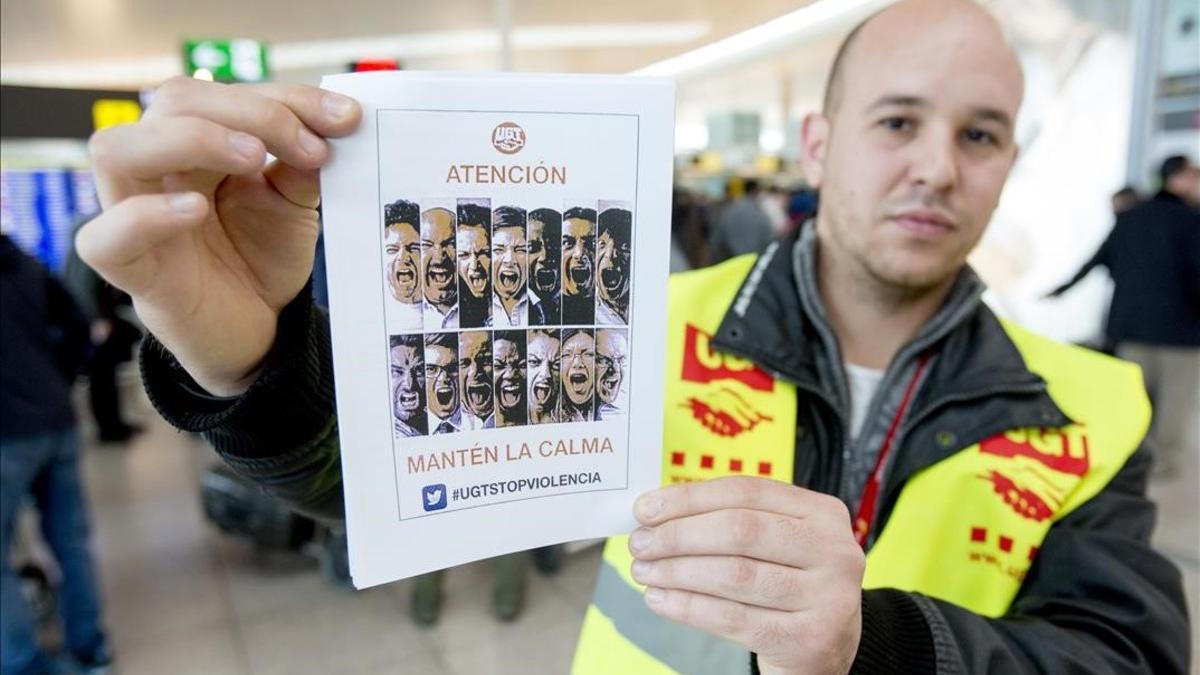 Un delegado de UGT con la octavilla de la campaña para frenar las agresiones a trabajadores en El Prat.