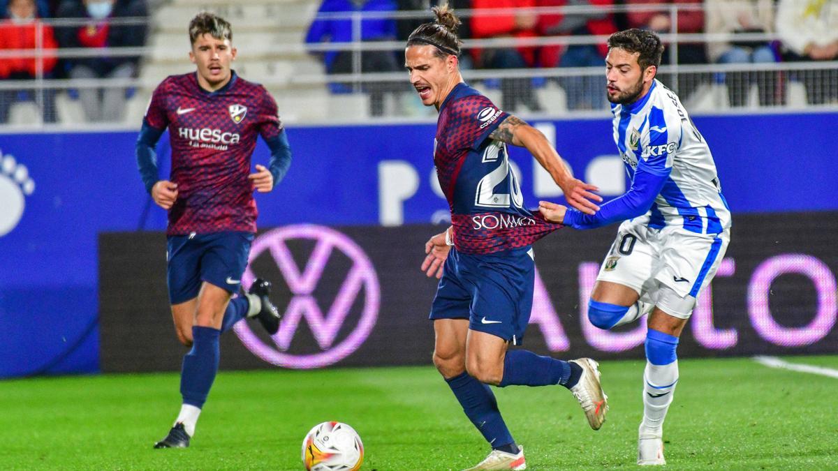 Arnaiz agarra de la camiseta al azulgrana Seoane durante el encuentro disputado en El Alcoraz.