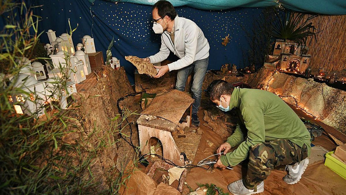 Dos voluntarios durante la instalación del nacimiento parroquial de Santa María.   | // GUSTAVO SANTOS