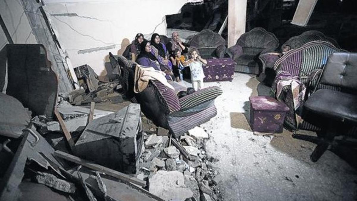 Una familia palestina observa las ruinas de su casa en Beit Hanun (Gaza).