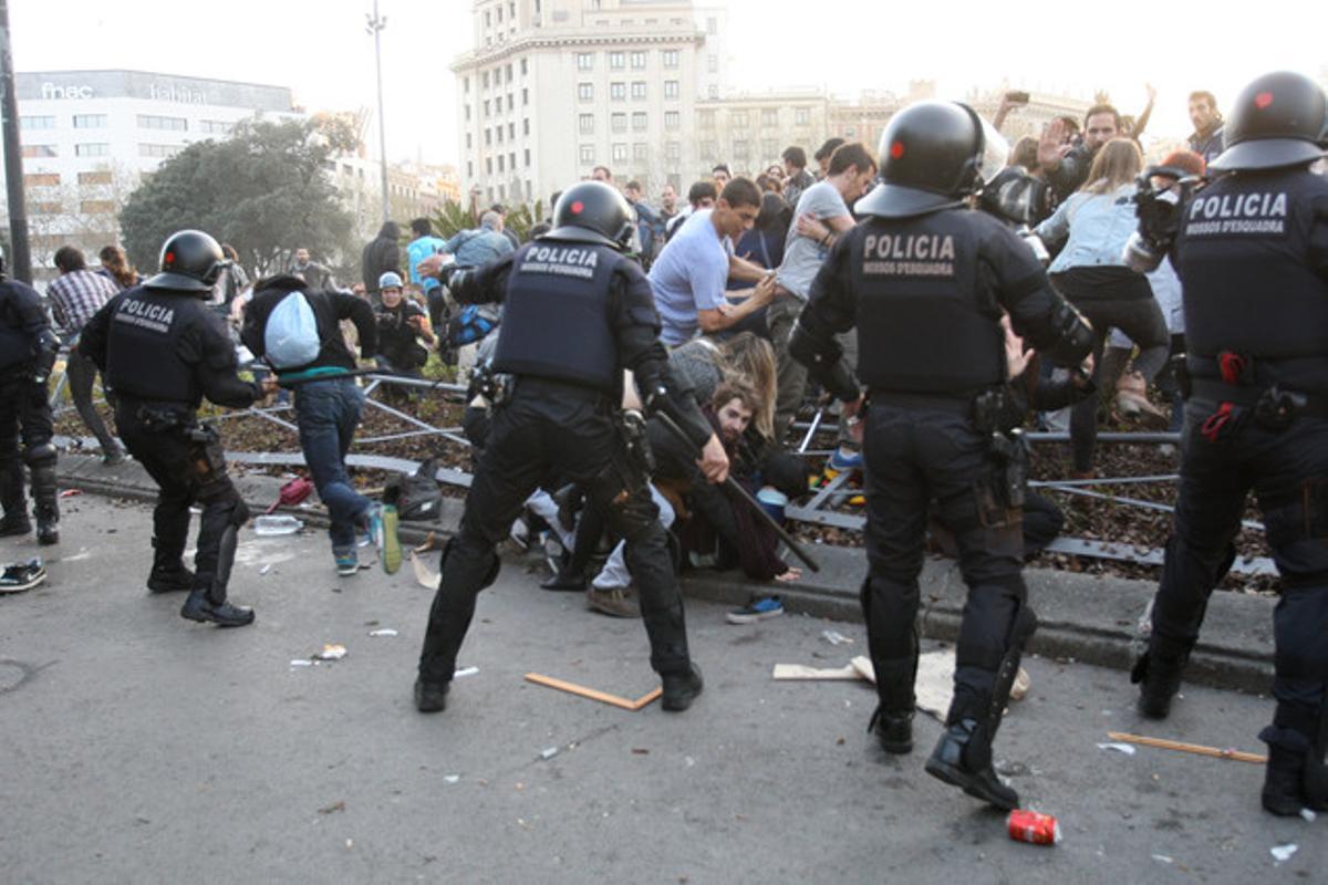 Agentes de la policía y alborotadores se enfrentan en la plaza de Catalunya.