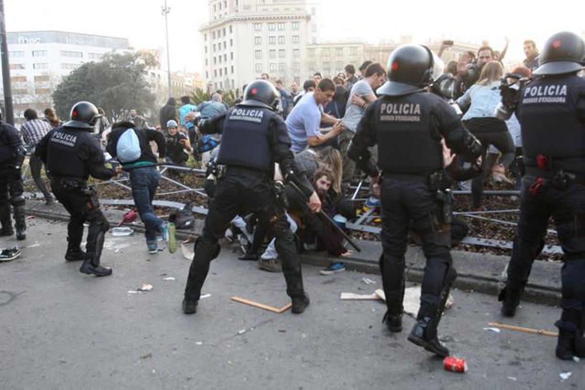 Agents de la policia i esvalotadors s’enfronten a la plaça de Catalunya.