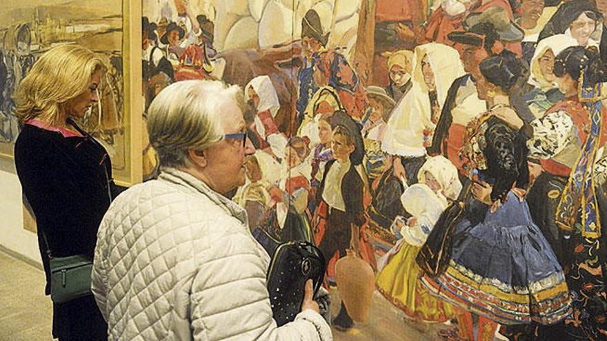 Dos visitantes observan uno de los bocetos de la muestra.