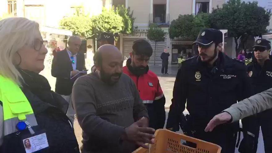 Alguien cercano al hombre encaramado en la fachada de la negocia habla con él