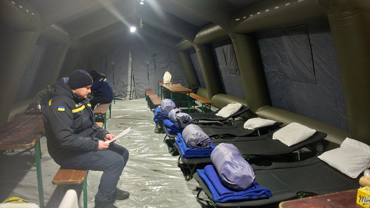 Un oficial de emergencias espera a las personas en una de las tiendas de campaña donde pueden calentarse y dormir tras los continuos ataques aéreos de Rusia.