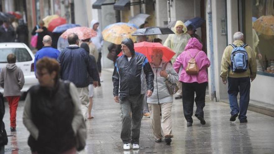 Turistas callejeando un día lluvioso.