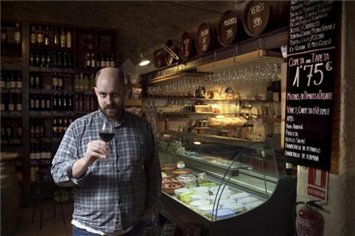 Eduard Burrull, con una copa ante una de las vitrinas de la bodega. Foto: Joan Cortadellas