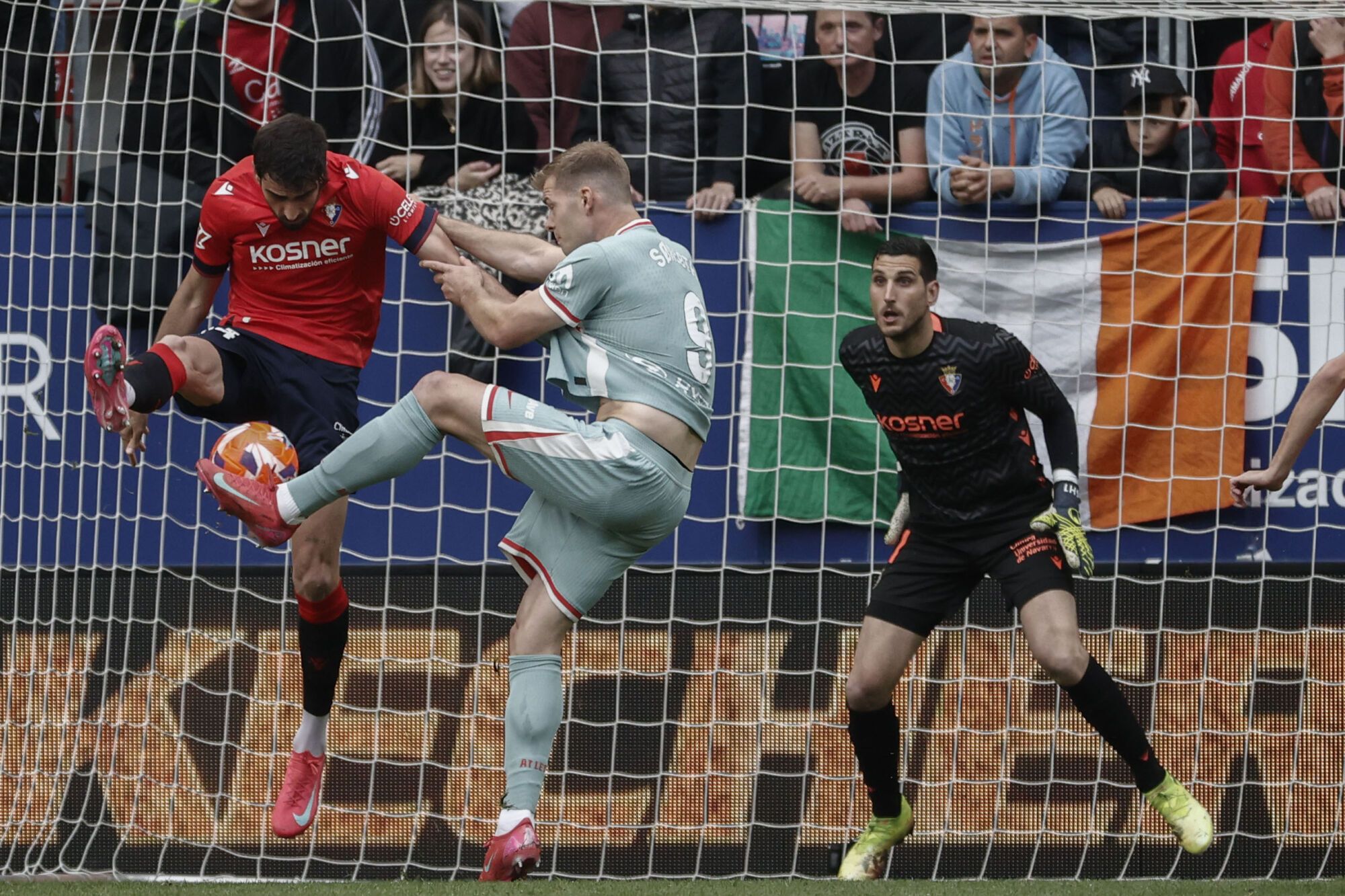 El defensa del Osasuna Alejandro Catena (i) intenta despejar un disparo del delantero noruego del Atlético de Madrid Alexander Sørloth (c) durante el encuentro correspondiente a la jornada 36 de LaLiga EA Sports entre el Osasuna y el Atlético de Madrid este jueves en el Sadar, Pamplona. EFE/ Jesús Diges. (Atlético Madrid) (Osasuna)