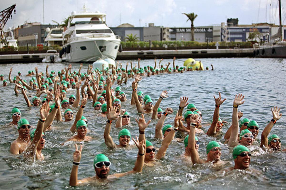 Els participants veterans de la 20a edició de la Travessia nedant del Port de València, en què han participat uns 800 nedadors, saluden abans de la sortida.