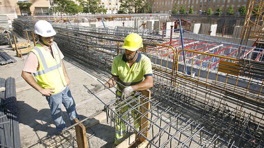 Dos treballadors en una obra a la ciutat de Girona.