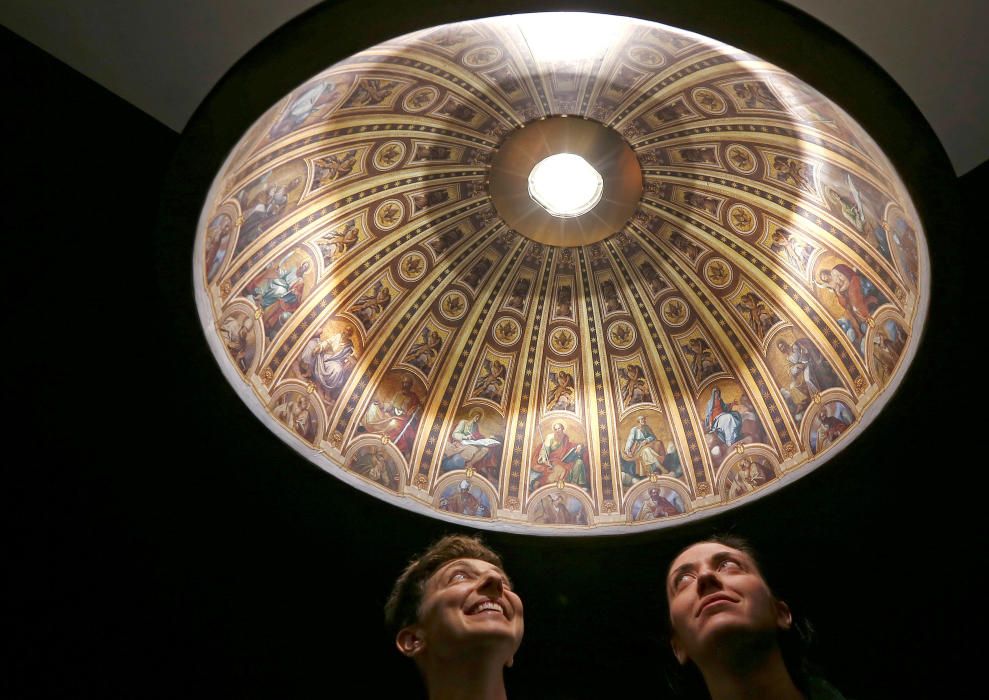 Las diseñadoras italianas Eleonora Barbareschi y Alessandra Mantovani posan bajo su lámpara, una representación hiperrealista de la basílica de San Pedro en la Semana del Diseño de Milán.