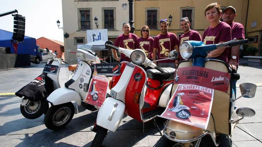 Miembros del Scooter Club Liada posan con varias motos Vespa y Lambretta en la plaza de Carlos Lobo.