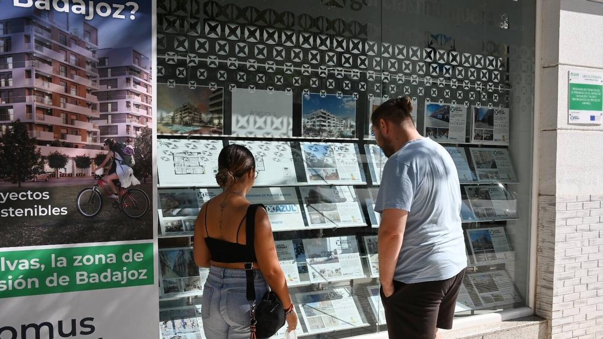 Una pareja mirar anuncios en una inmobiliaria.